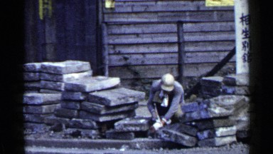 1953: man is breaking rock while other worker is walking is the back JAPAN