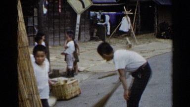 1953: children in the street playing and sweeping the road JAPAN