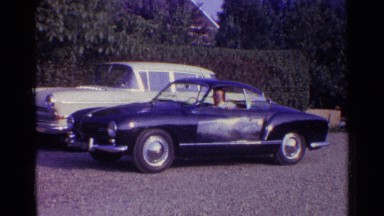 1961: man parking the classic car and walking out of the car with a big smile