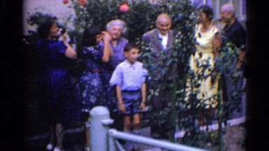 1961: family member are giving posture for photo,women try to kiss the boy