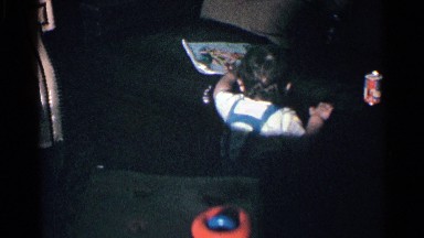 1963: A Little Boy in a T-Shirt and Blue Overalls Pulling Himself Up