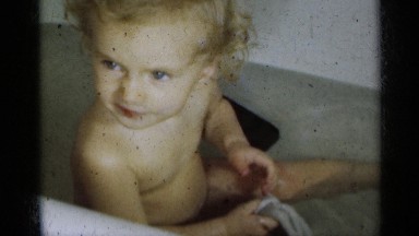 1939: Young Child with Blonde Curly Hair Sits in Tub and Bathes Michigan