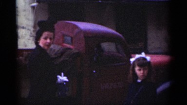 1949: very charming mother and child standing beside a truck parked