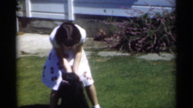 1949: the beautiful child playing with the dark black dog NEW ORLEANS LOUSIANA