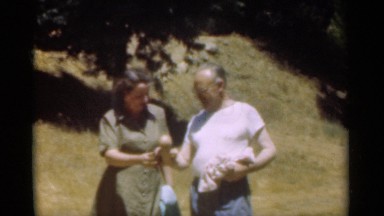 1949: one lady and one old man walking by side by side each other and smiling