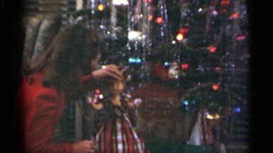 1949: girl plays with new doll under christmas tree. SANTA CRUZ CALIFORNIA
