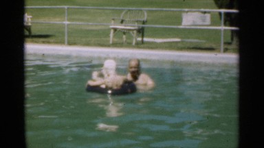 1949: a kid sit on the swimming pool balloon with her father