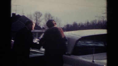 1959: A Man Escorting a Woman to a Car and Helping Her Into the Back Seat Ohio