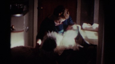 1959: woman holds baby in one arm and pats dog with other when nurse enters OHIO