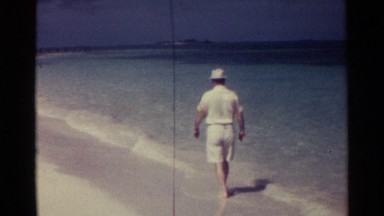 1963: A Man Strolling Along Nassau Beach Through Shallow Surf