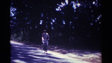 1963: woman rides a bicycle through the neighborhood. NASSAU BAHAMAS