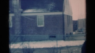 1939: vehicles going down a road with a field nearby that appears to be barren
