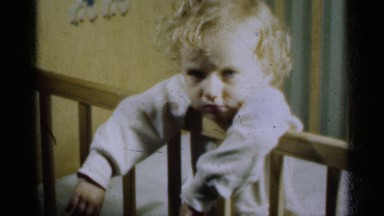 1939: a beautiful little blonde girl in a crib who appears to be praying