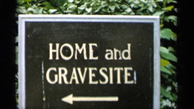 1956: signs showing directions in front of brush and a gravestone JONES BEACH