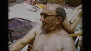 1956: An Old Man Sitting Naked with a Cooling Glass to Bath in the Sunshine at Jones Beach, New York