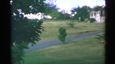 1967: road cuts through grassy slope toward structure shaped like an ark US