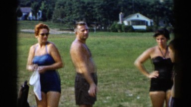 1955: A Group of Family Friends Relaxing in Swimwear on the Shore of a Lake