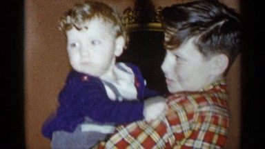 1955: an older boy holds a toddler who is on the verge of tears NEW YORK CITY
