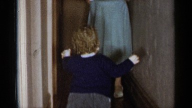 1955: little girl wobbles on unsteady feet toward mother. NEW YORK CITY