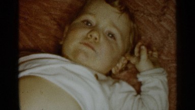 1955: a baby is sleeping on the bed, his face looks like ugly NEW YORK CITY