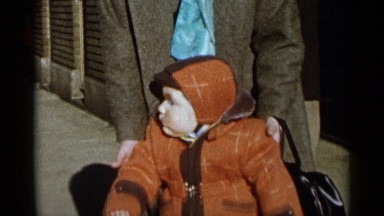 1955: bundled up child turns and runs away from the camera after seeing it