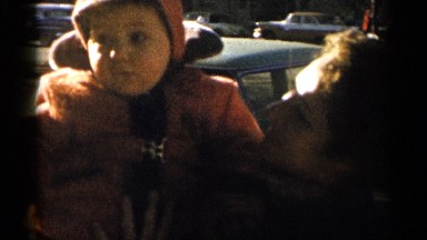 1955: a woman taking to a child, giving him a kiss while holding him in her arms