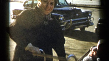 1955: young mother shows off her little baby in a baby carriage on a cold day
