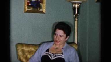 1955: a woman talking to someone and she is holding something in her hand