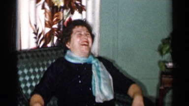 1955: a cute old lady sitting in the couch and chatting cheerfully NEW YORK CITY