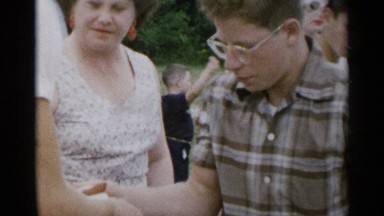1954: Young Man Hands a Hot Dog to an Older Man