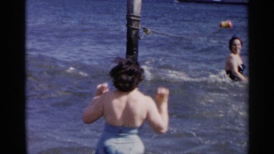1954: a family enjoying a soak in the lake and splashing and swimming