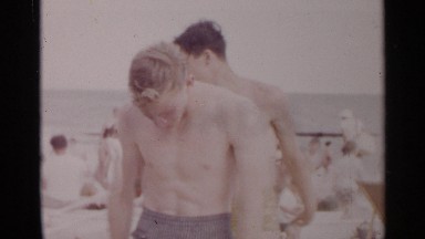 1954: young man leaping over his friend at a crowded beach NEW YORK