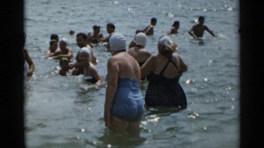 1954: a group of people enjoying the refreshing coolness of the sea water