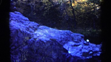 1960: green forest with rocky mountain with a natural spring flowing over it.