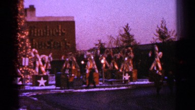 1964: big sized christmas candy in road side with christmas tree people enjoying