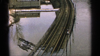 1965: aerial footage of a flooded town with water over train tracks. MINNESOTA