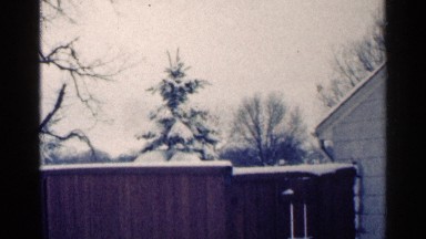 1964: winter season shows the snow covered fence and house roof full of white