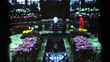 1964: a lady walking around a garden with flowers. MINNESOTA