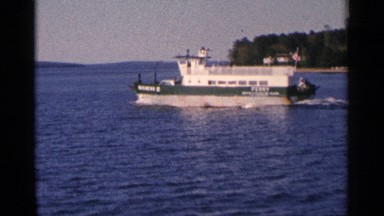 1964: white and green ship sails in the ocean, with an american flag