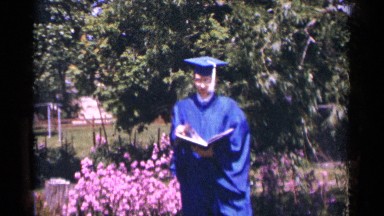 1964: A Young Man Stands Outside Wearing His Blue Graduation Uniform