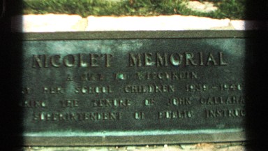1964: a board that represent the sign nicolet memorial and a statue near