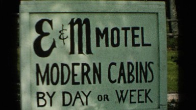 1964: a sign of board that represent a cabins advertisement and a car parking
