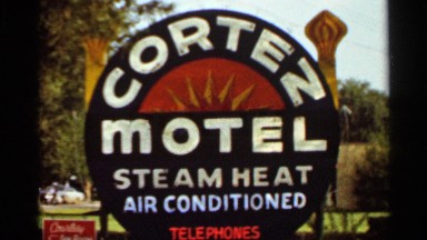 1965: round sign by busy street announces cortez motel and its amenities KANSAS