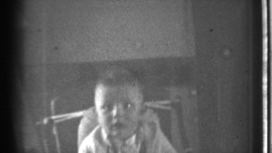 1939: A Male Baby Child Sitting in a Chair Crying and Looking for Someone