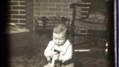 1939: a funny moment, baby playing with an instrument seem to him as his toy
