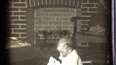 1939: baby sitting on the floor playing in front of the fireplace. DANIELSON