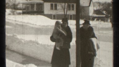 1939: two women walk the street take the child near the house window