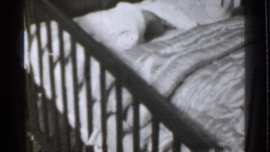 1939: a small baby sleeping at a baby cot and looking all side around DANIELSON