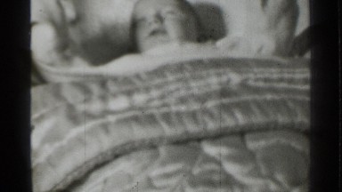 1939: small children play in the bed cover for the cloth baby is very happy