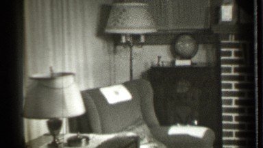 1939: the lady sit the sofa in near the lamp and do her work in his house
